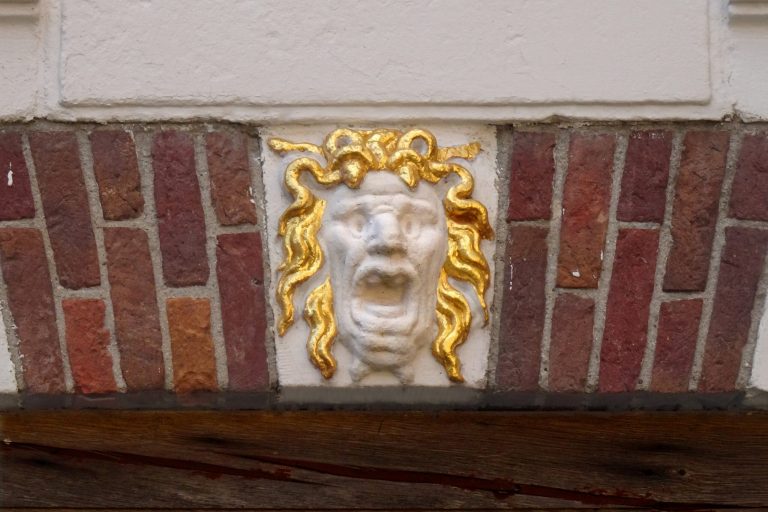 Foto van een gevelsteen in de poort van het Hofje van Sonoy van Medusa.